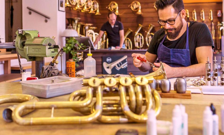 Ein Musikinstrumentenbauer baut eine Trompete