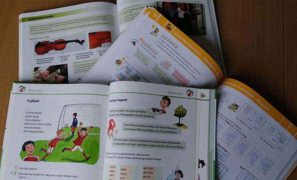 Symbolbild: verschiedene aufegschlagene Schulbücher für die Grundschule.