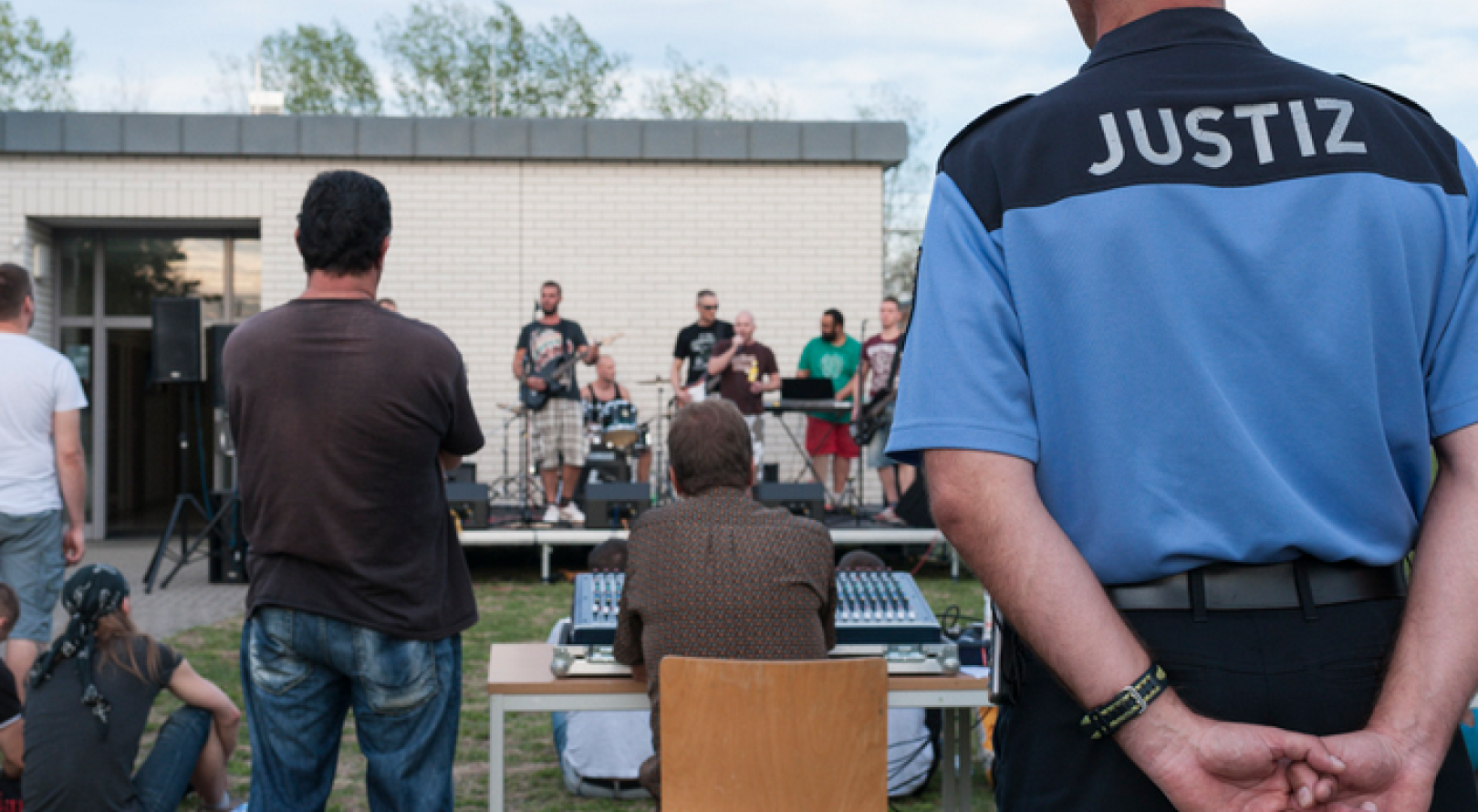 Foto eines Justizvollzugsbeamten, der einer Band zuschaut