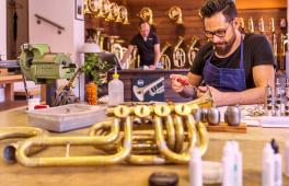 Ein Musikinstrumentenbauer baut eine Trompete