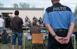 Foto eines Justizvollzugsbeamten, der einer Band zuschaut