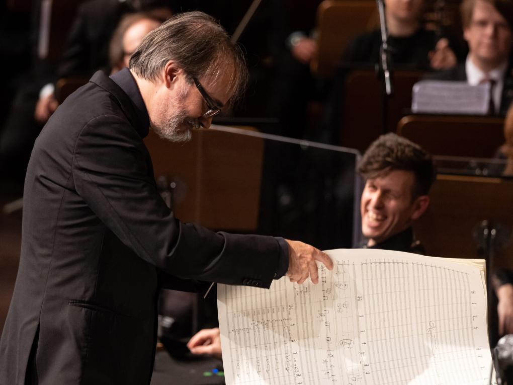 Dirigent blättert in einer großen Partitur