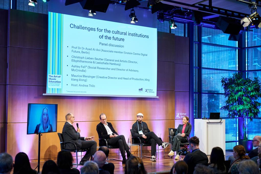 Eine Panel-Diskussion mit vier Personen während einer Konferenz