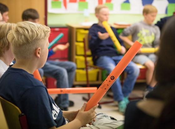 Tag der Musik an der Hochschule für Musik und Theater Rostock. Die Kinder sitzten mit Boomwhackern in einem Stuhlkreis.