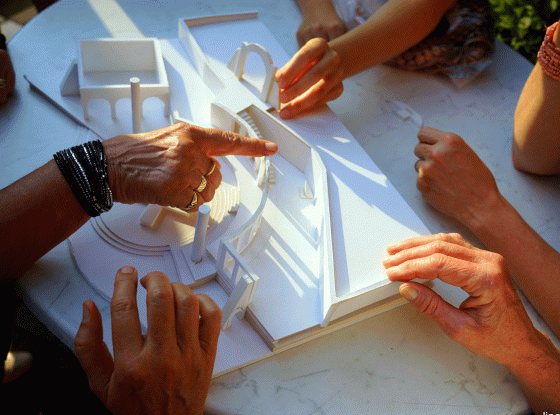 Sehbehinderte und Blinde ertasten das Holzmodell eines Bühnenbilds im Staatstheater Augsburg